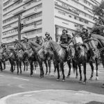 Policiais montados patrulham uma rua de São Paulo em imagem em preto e branco.