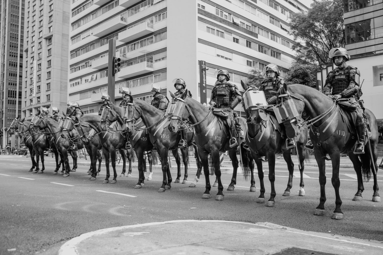 Policiais montados patrulham uma rua de São Paulo em imagem em preto e branco.